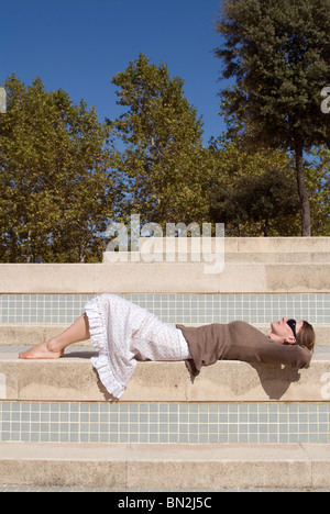 Femme couchée sur une étape et se détendre au soleil Banque D'Images