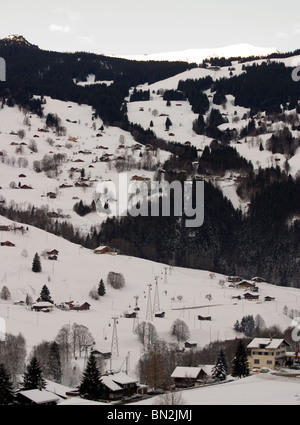 Alpes suisses de ski : Grindelwald Maisons de village couvert de neige et de ski télécabine Männlichen ski area. Banque D'Images