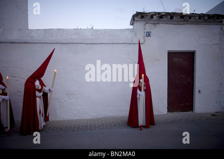 Pénitents à pied dans une rue à Pâques célébrations de la Semaine Sainte en Espera village, province de Cadix, Andalousie, Espagne Banque D'Images