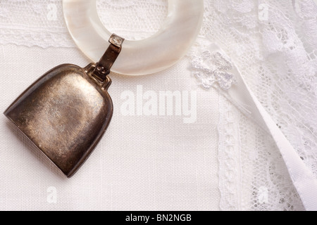 Hochet bébé vintage avec bague de nacre isolé sur un linge blanc Banque D'Images