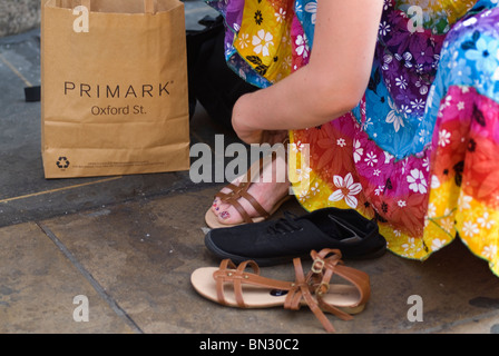 Essayer une nouvelle paire de chaussures. PRIMARK sandales à bout ouvert, tout juste acheté à l'extérieur du magasin à Oxford Street Londres Angleterre 2012 UK 2010 HOMER SYKES Banque D'Images