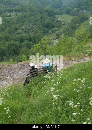 Deux personnes assises sur un banc à profiter de la vue de Monsal Head, Derbyshire, Angleterre, Royaume-Uni Banque D'Images
