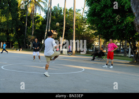 Hommes thaïlandais jouer jeu de balle en rotin (Takraw) sur un lieu public à Chiang Mai, Thaïlande, Asie Banque D'Images