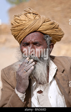 Old Indian man smoking a cigarette indienne (biri). Jaisalmer. Le Rajasthan. L'Inde Banque D'Images