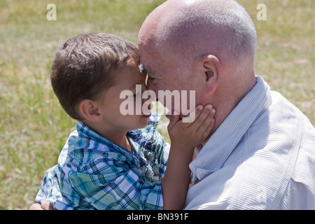 Eldery homme jouant de pincer le nez avec son petit-fils Banque D'Images