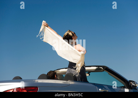 Femme debout dans les bras tendus avec convertible Banque D'Images