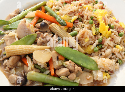 repas sauté de poulet et de légumes chinois servi avec du riz au jambon sur une assiette Banque D'Images