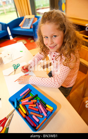 Jeune fille dessin avec des crayons de cire, elevated view Banque D'Images