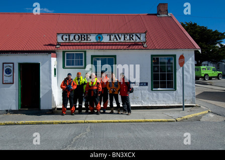 Groupe d'hommes en face du Globe Tavern, Stanley, East Falkland Banque D'Images