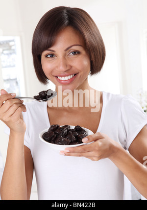 WOMAN EATING pruneaux Banque D'Images