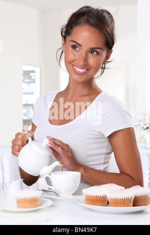 Femme avec thé et gâteaux de tasse Banque D'Images