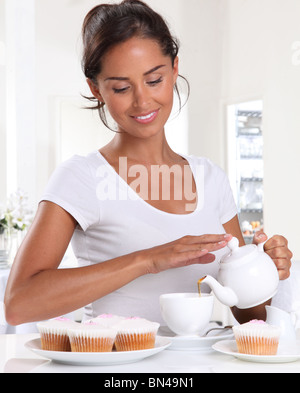 Femme avec thé et gâteaux de tasse Banque D'Images