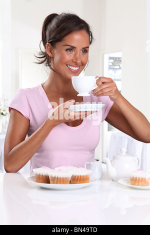 Femme avec thé et gâteaux de tasse Banque D'Images