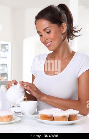 Femme avec thé et gâteaux de tasse Banque D'Images