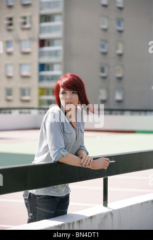 Red haired woman fumer dehors. Banque D'Images