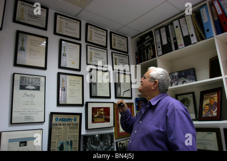 Producteur et réalisateur israélien Menahem Golan regarde ses nombreuses récompenses, accroché au mur de son bureau à Tel-Aviv. Banque D'Images