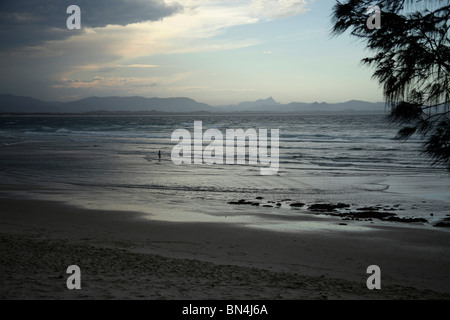 Seul nageur à une plage peu avant un orage à Byron Bay, New South Wales, Australia Banque D'Images