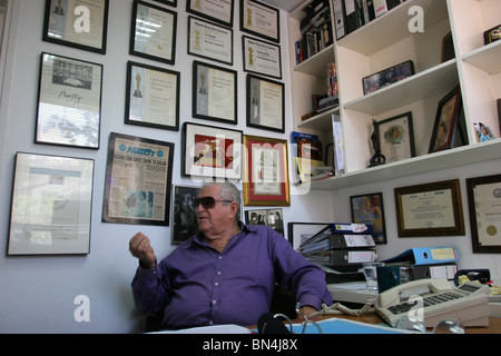 Producteur et réalisateur israélien Menahem Golan regarde ses nombreuses récompenses, accroché au mur de son bureau à Tel-Aviv. Banque D'Images