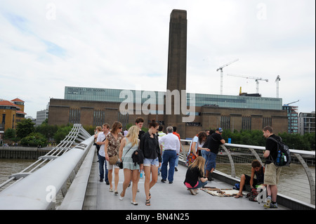 Vue de la Tate Modern Art Gallery et personnes traversant le pont du Millénaire. Southbank, Londres. Banque D'Images