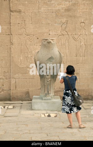 Tourisme une femme prise d'une photo d'une statue de l'ancien dieu égyptien, Horus, temple d'Edfou, Egypte Banque D'Images