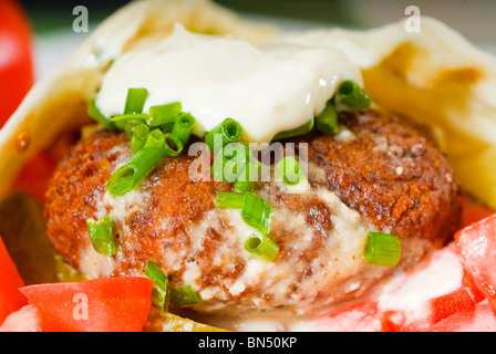 Falafel traditionnelle frais emballage sur le pain pita avec des tomates fraîches hachées Banque D'Images