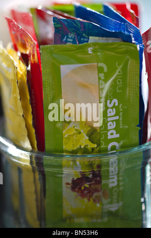 Sachets de crème de salade et d'autres condiments dans un pot dans un café. Banque D'Images