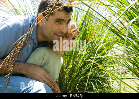 Père et fils se cacher dans l'herbe haute Banque D'Images