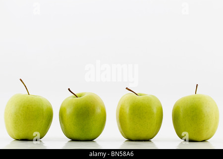 Quatre pommes vertes sur fond blanc Banque D'Images