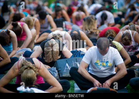 Des centaines de pratiquants de yoga de tous les niveaux participent à une classe de yoga donnés dans Bryant Park à New York Banque D'Images