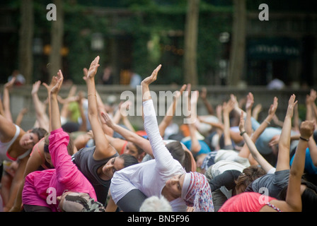 Des centaines de pratiquants de yoga de tous les niveaux participent à une classe de yoga donnés dans Bryant Park à New York Banque D'Images