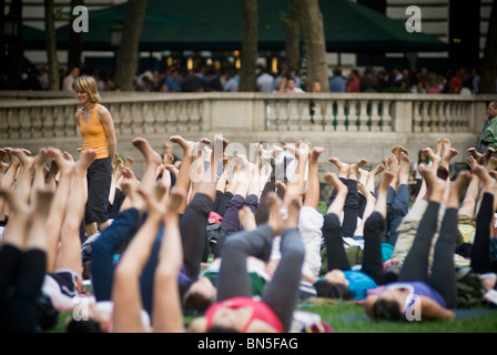 Des centaines de pratiquants de yoga de tous les niveaux participent à une classe de yoga donnés dans Bryant Park à New York Banque D'Images