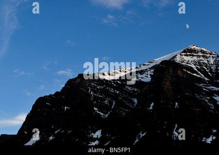 Lune suspendue au-dessus de montagnes. Le parc national Banff, Alberta, Canada. Banque D'Images