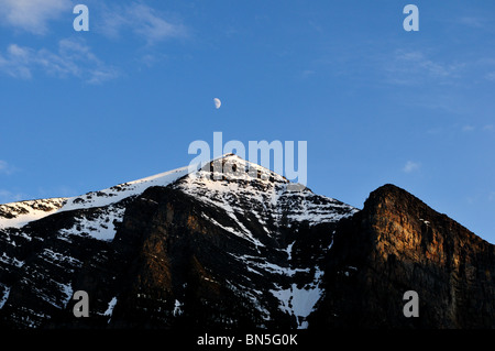 Lune suspendue au-dessus de montagnes. Le parc national Banff, Alberta, Canada. Banque D'Images