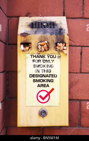 Cigarette surchargé bin sur mur extérieur Banque D'Images