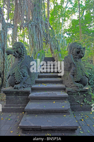 Deux immenses statues de dragon en pierre qui gardent les escaliers au saint Temple et bassin de baignade. La forêt des singes sacrés. Ubud, Bali. Banque D'Images