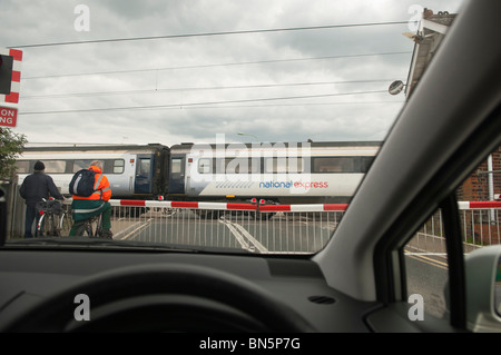 Une photo prise depuis l'intérieur d'une voiture à un passage à niveau qu'un train passe à travers au Royaume-Uni Banque D'Images
