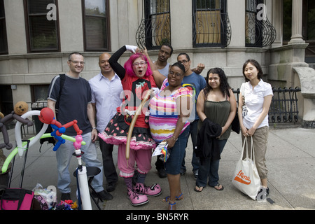 Un groupe de gens posent avec un clown à gonfler des ballons la Gay Pride Festival à Park Slope, Brooklyn, New York. Banque D'Images