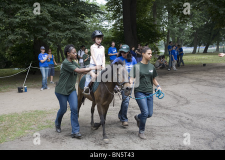 Les enfants handicapés reçoivent un apprentissage de thérapie développementale pour faire du cheval, connu sous le nom d'hippothérapie i9n Prospect Park, Brooklyn, NY. Banque D'Images