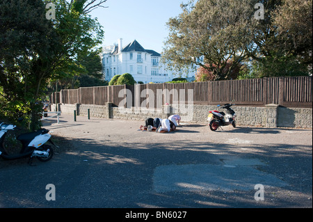 Les hommes musulmans prier sur le chemin d'East Cliff, près de la plage de Bournemouth. Banque D'Images