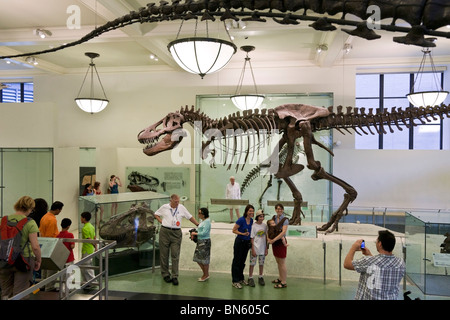 Père de prendre photo de famille heureuse qui pose à côté de tyrannosaure squelette dans American Museum of Natural History New York City Banque D'Images