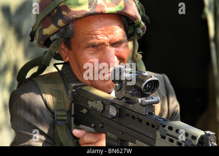 Soldat vétéran Gurka Bornéo avec fusil d'assaut moderne SA80 et le casque à l'événement de la journée des forces armées. Banque D'Images