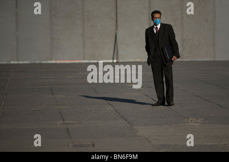 Un homme porte un masque par mesure de précaution contre la grippe porcine dans le Zocalo, la place principale de la ville de Mexico. Banque D'Images
