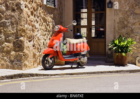 Scooter rouge garée dans la rue. Banque D'Images