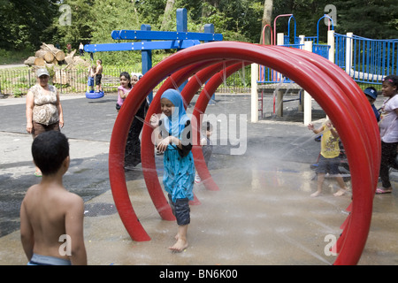 Les enfants se rafraîchir dans le domaine de l'eau par une chaude journée d'été à la 3e Rue à Prospect Park, Brooklyn, New York. Banque D'Images