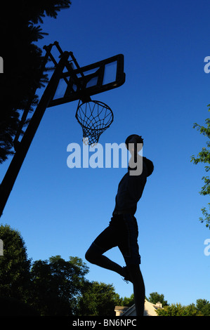 Jouer au basket-ball à la maison dans l'allée Banque D'Images