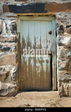 Bâti en pierre avec la peinture écaillée de la vieille porte en bois. La lumière du soleil sur le bâti en pierre. Montagnes de Magaliesberg, Province de Gauteng, Afrique du Sud Banque D'Images