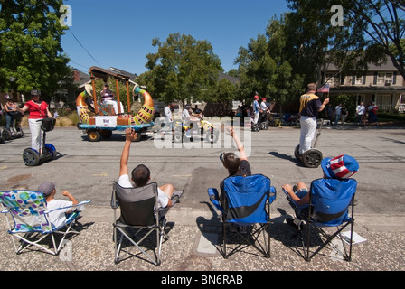 Vague de spectateurs à Steve Wozniak comme lui et son posse sur Segways col au cours d'un défilé du 4 juillet à San Jose, CA. Banque D'Images