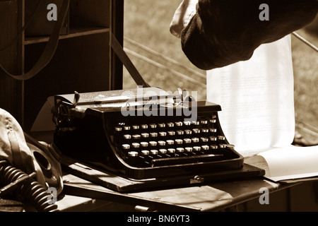 Une personne à la recherche militaire au soldat lettres dactylographiées sur une antique machine à écrire à une reconstitution WW2 camping Banque D'Images