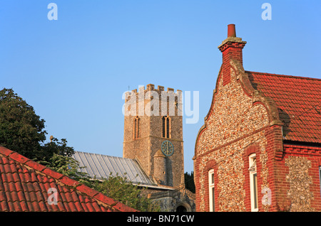 La tour de l'Église à Glandford, Norfolk, Angleterre, Royaume-Uni, vue entre les bâtiments de Norfolk. Banque D'Images