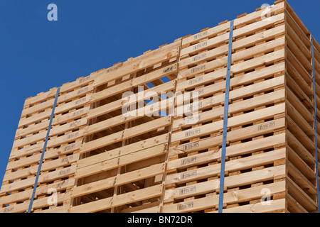 Palettes empilées contre un ciel bleu Banque D'Images